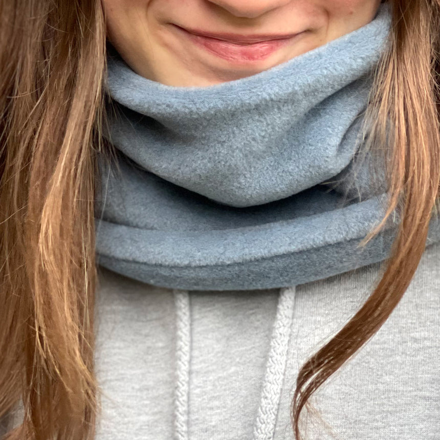 Frau trägt Wollhuhn WINTER Halstuch/Schlupfschal „Unser Wärmster“, doppellagiger Fleece, schützt zuverlässig Hals und Nacken, handgemacht, ideal für kalte Tage.