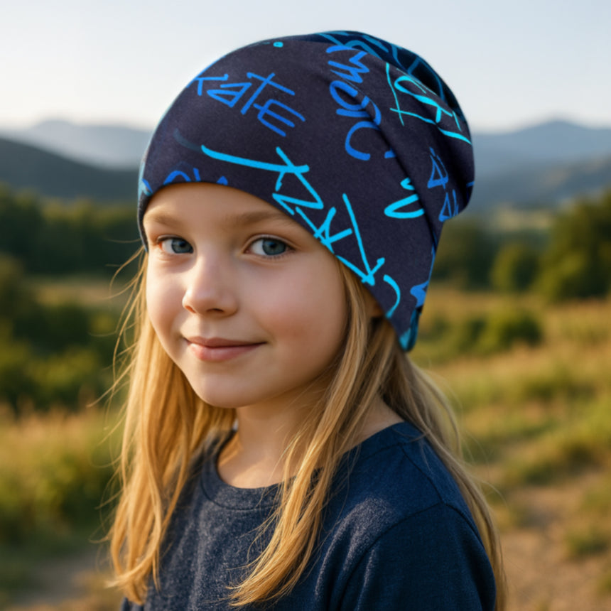 Mädchen trägt die Wollhuhn Öko Long Beanie, Wendemütze, zweilagig aus Baumwolljersey, ideal für ganzjähriges Tragen und wächst mit, komfortabel und stilvoll.