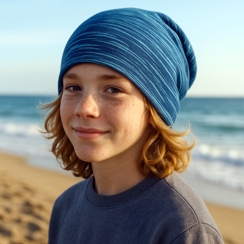Junge trägt eine Wollhuhn Öko Long Beanie Wendemütze am Strand, lässig geschnitten, zweilagig und bequem. Perfekt für das ganze Jahr.