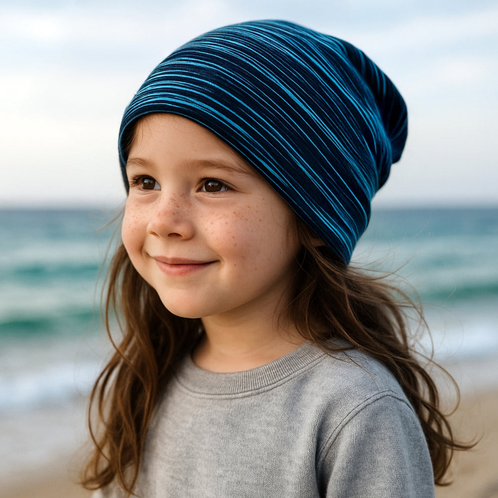 Wollhuhn Öko Long Beanie auf dem Kopf eines lächelnden Kindes, zeigt die bequeme Passform und die zweilagige Verarbeitung der Mütze.