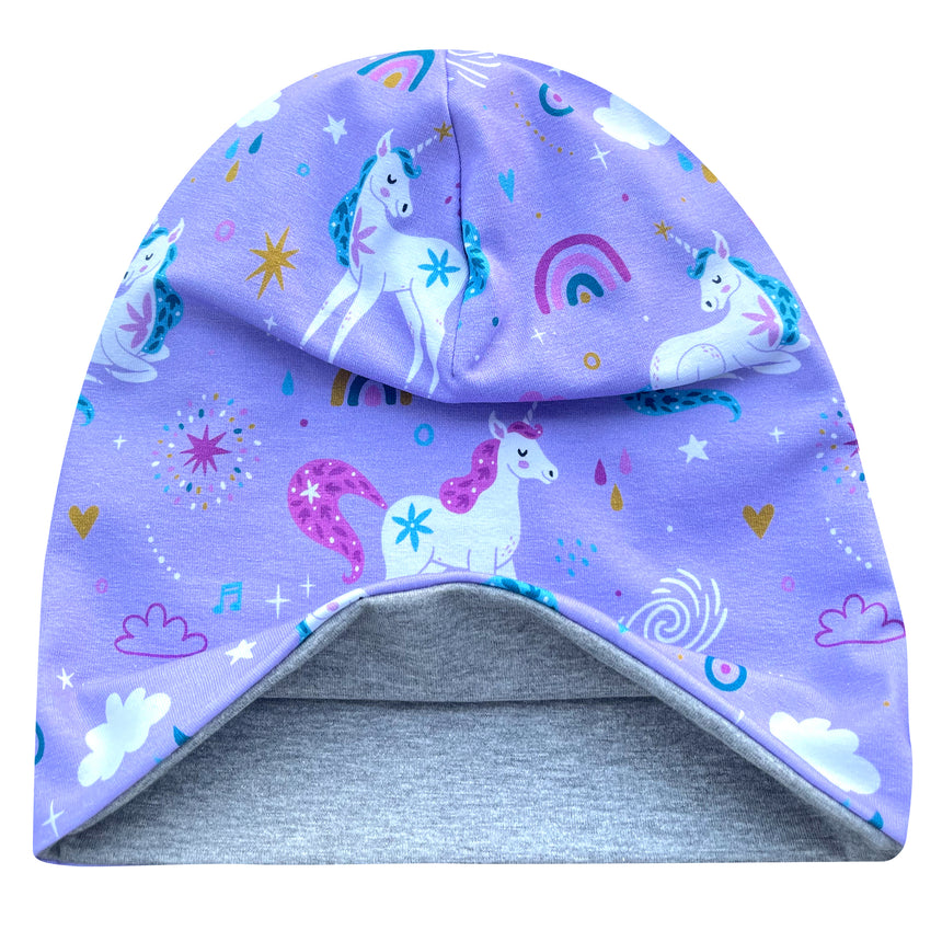 Wollhuhn Öko Long Beanie, fliederfarben mit Einhörnern und Regenbögen, zweilagig und wendbar, aus weichem Baumwolljersey, ideal für ganzjähriges Tragen.