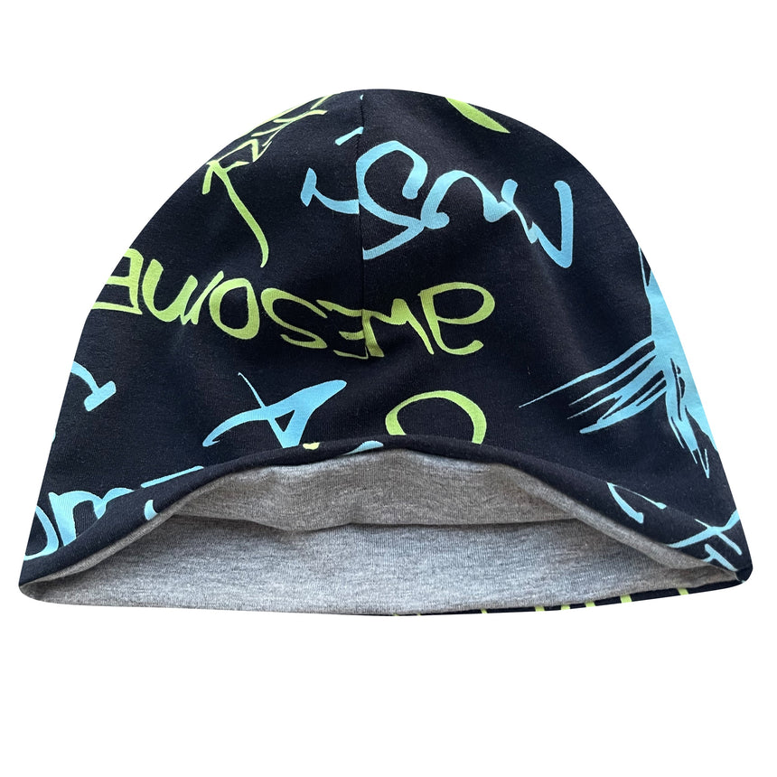 Wollhuhn Öko Shorties Wendemütze: Schwarze Beanie mit blau-grünem Schriftzug, aus weichem Baumwolljersey, zweilagig und wendbar, ideal für ganzjährigen, bequemen Tragekomfort.