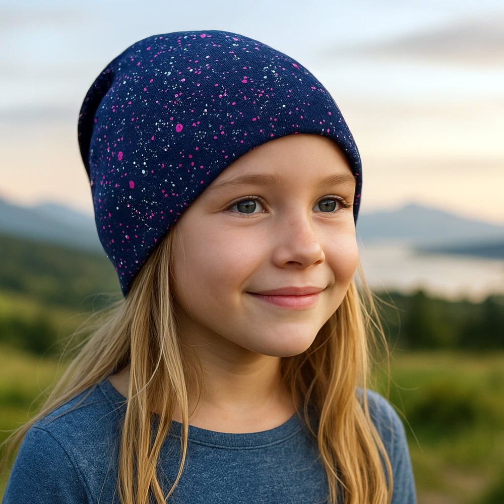Mädchen trägt eine Wollhuhn Öko Shorties Wendemütze, ideal für Kinder, handgefertigt aus Öko-Jersey, komfortabel und mitwachsend. Perfekt für Schule und Freizeit.