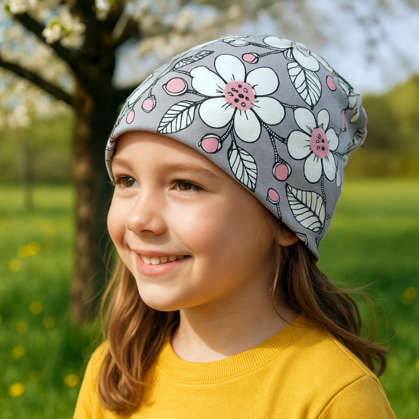 Mädchen trägt Wollhuhn Öko Shorties Wendemütze, ideal für aktive Kinder. Handgemacht aus Öko-Jersey, mitwachsend, zweilagig, perfekt für Alltag und Sport.