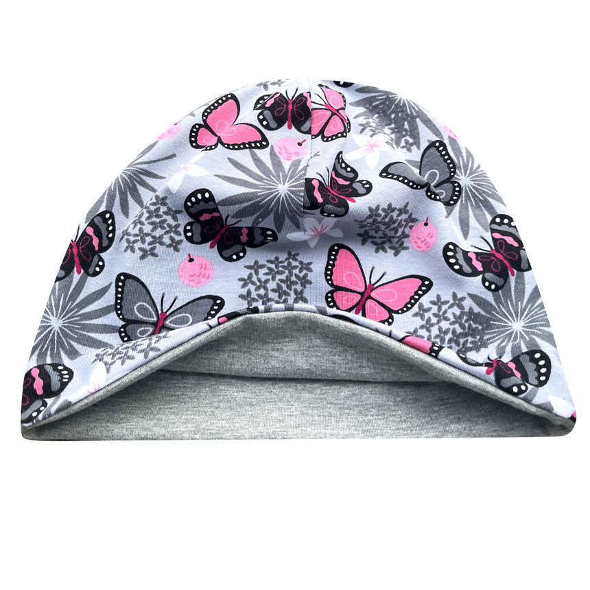 Wollhuhn Öko Shorties: Graue Wendemütze mit Schmetterlingen, handgefertigt aus weichem Öko-Jersey, ideal für aktive Kinder und Jugendliche.