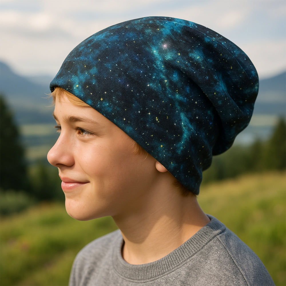 Junge trägt Wollhuhn Öko Shorties, Wendemütze, zweilagig, Space Blau/Grün, lächelt im Freien, weiche Beanie für aktive Kinder, handgemacht in Deutschland.
