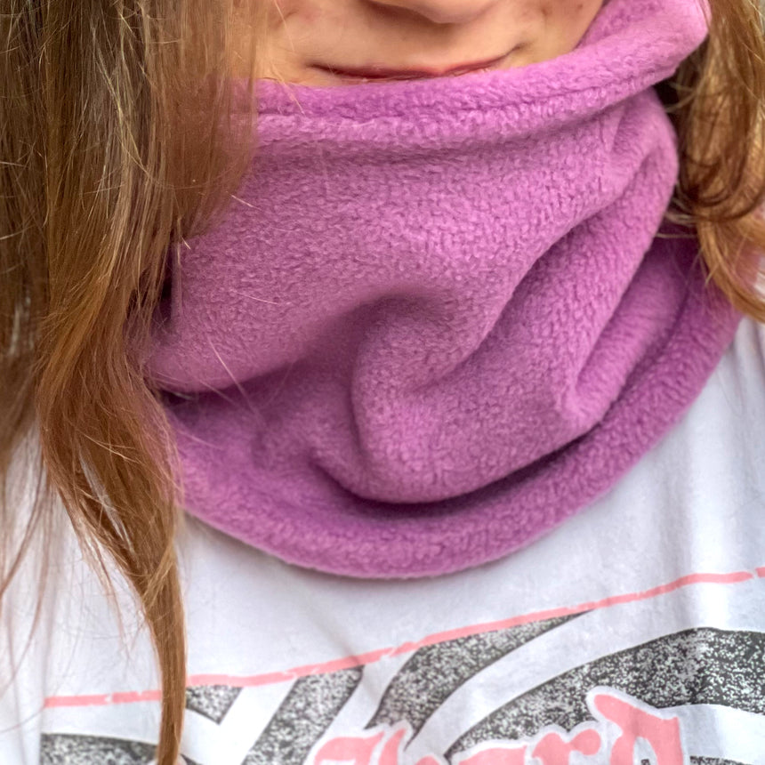 Mädchen trägt Wollhuhn WINTER Halstuch/Schlupfschal „Unser Wärmster“, doppellagiger Fleece in Flieder, handgefertigt, ideal für Kinder und Erwachsene, schützt vor Kälte.