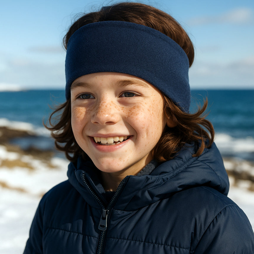 Ein Junge trägt das Wollhuhn Elastisches Öko Stirnband SPORTFLEECE in Royalblau, perfekt für kaltes Wetter, handgefertigt in Deutschland, schützt Ohren zuverlässig vor Wind.