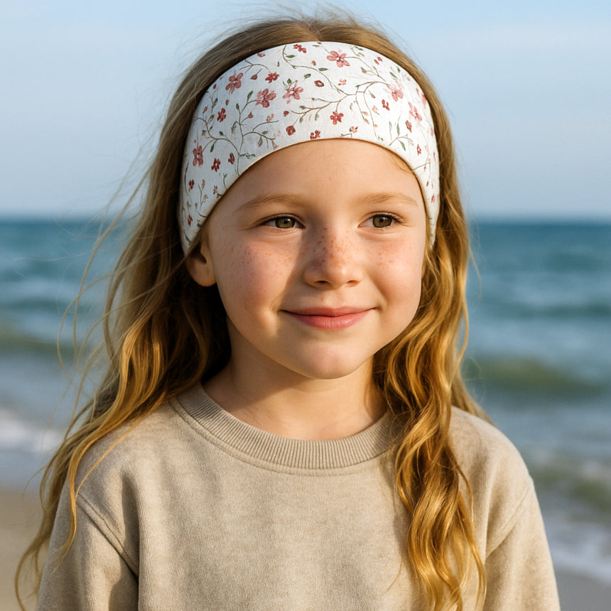 Mädchen trägt Wollhuhn Elastisches Öko Stirnband/Haarband Jersey Zweilagig Breit, zeigt Design und Passform des handgemachten Accessoires aus Bio-Baumwolle.