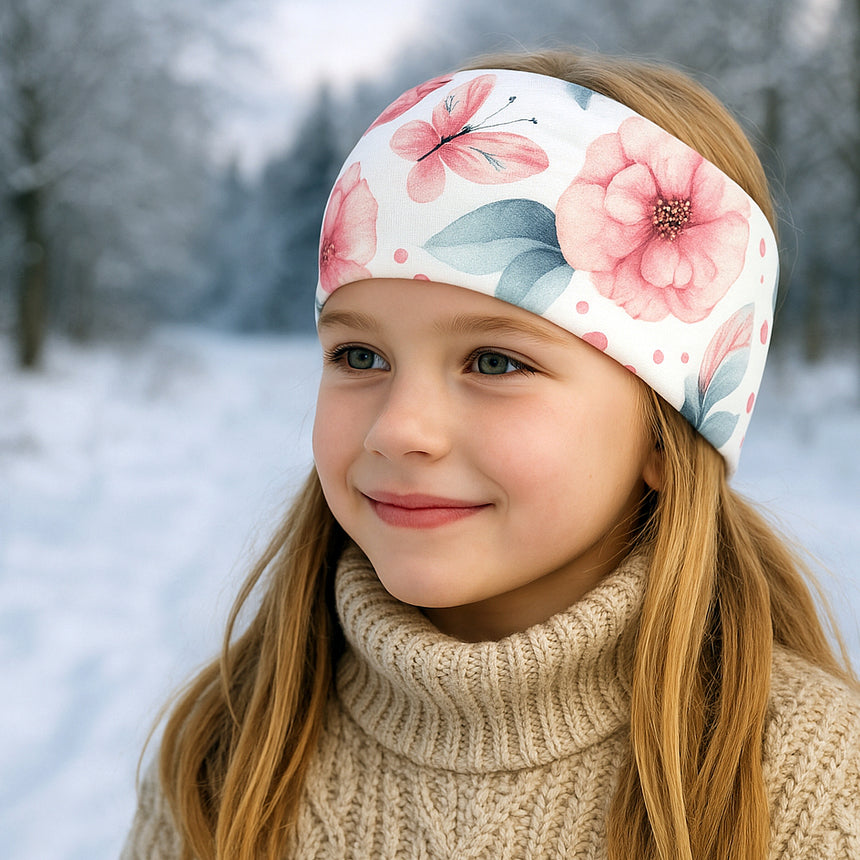 Mädchen im Schnee trägt Wollhuhn Elastisches Öko Stirnband/Haarband Jersey Zweilagig Breit. Handgemacht, ideal für Outdoor-Aktivitäten, passt Kindern und Erwachsenen.