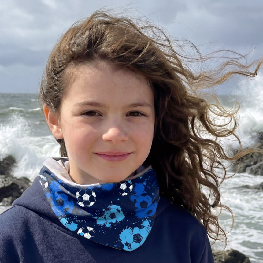 Mädchen am felsigen Ufer trägt Wollhuhn Leichtes Öko Jersey Halstuch mit Fußballmotiv, windiger Tag, ideal für Frühling, Sommer und Herbst.