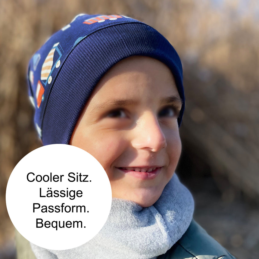 Kind trägt Wollhuhn Dünne Öko Beanie-Mütze, Sommer/Übergang, einlagig, bequem, dehnbar, ideal für Übergangszeit, handgemacht in Deutschland. Perfekt für aktive Kinder.