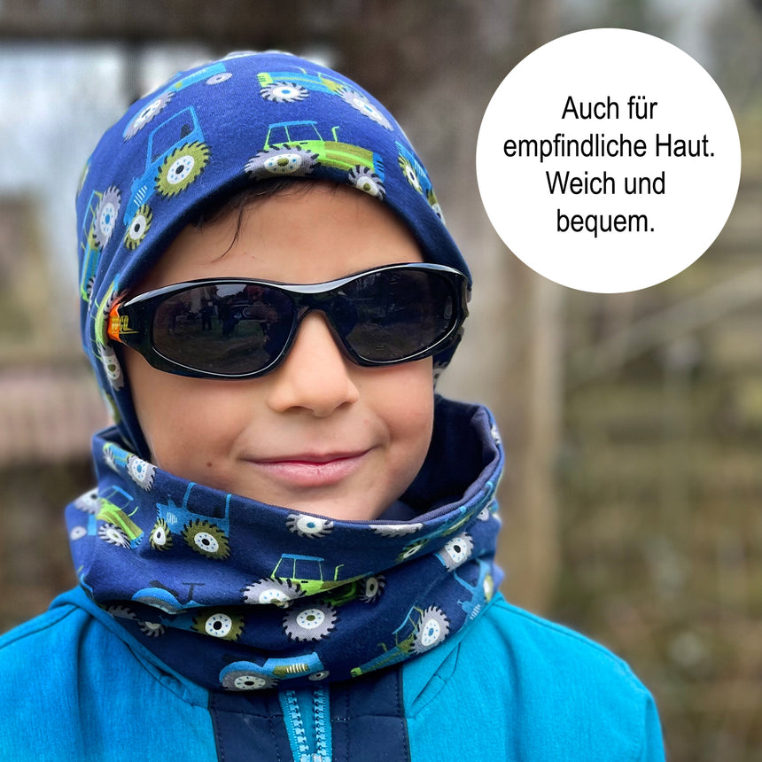 Junge mit Sonnenbrille und Schal, trägt den Wollhuhn LONG Loop, Jersey- oder Fleecefutter, ideal für Schutz und Komfort bei Wind und Wetter.