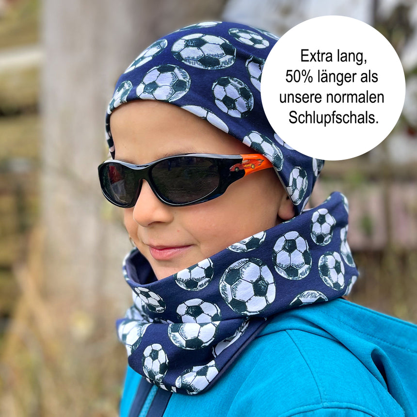 Ein Junge trägt den Wollhuhn LONG Loop Schal in Pink, kombiniert mit Sonnenbrille und Schal, ideal für Komfort und Schutz in jeder Jahreszeit.