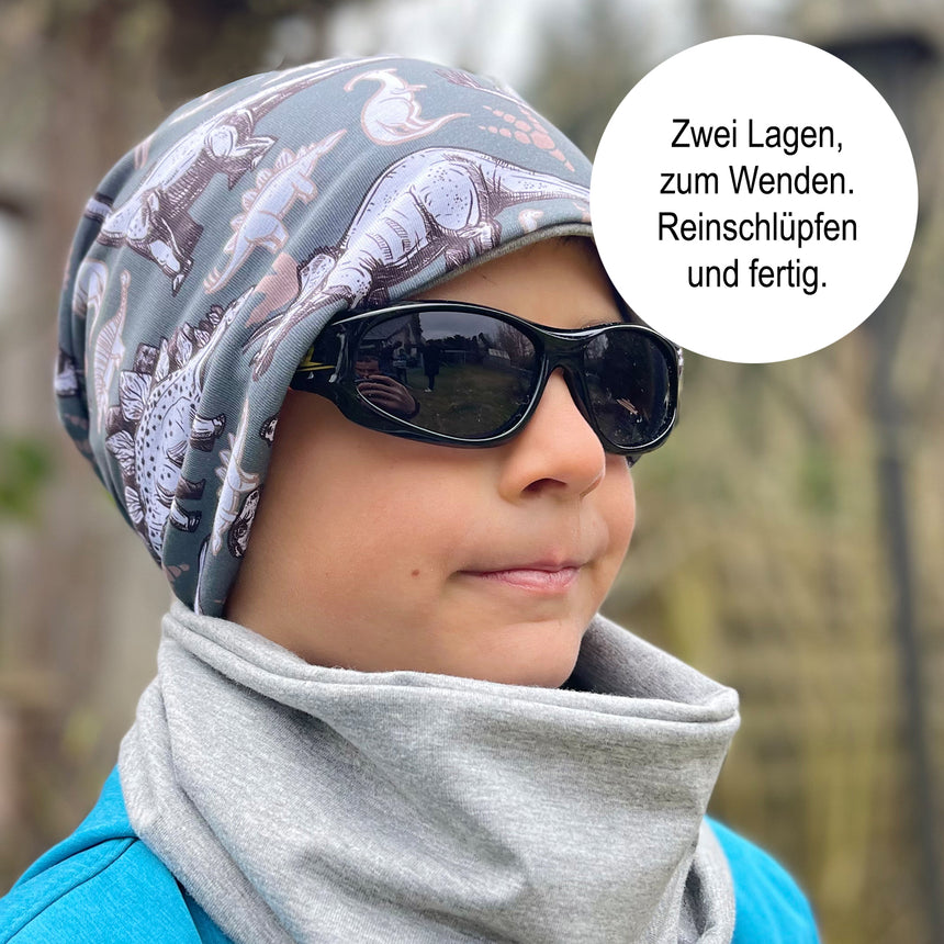 Person trägt Wollhuhn LONG Loop, Jersey- oder Fleecefutter, Space Neon Gelb, als modisches Accessoire um den Hals, kombiniert mit Sonnenbrille und Kopftuch.