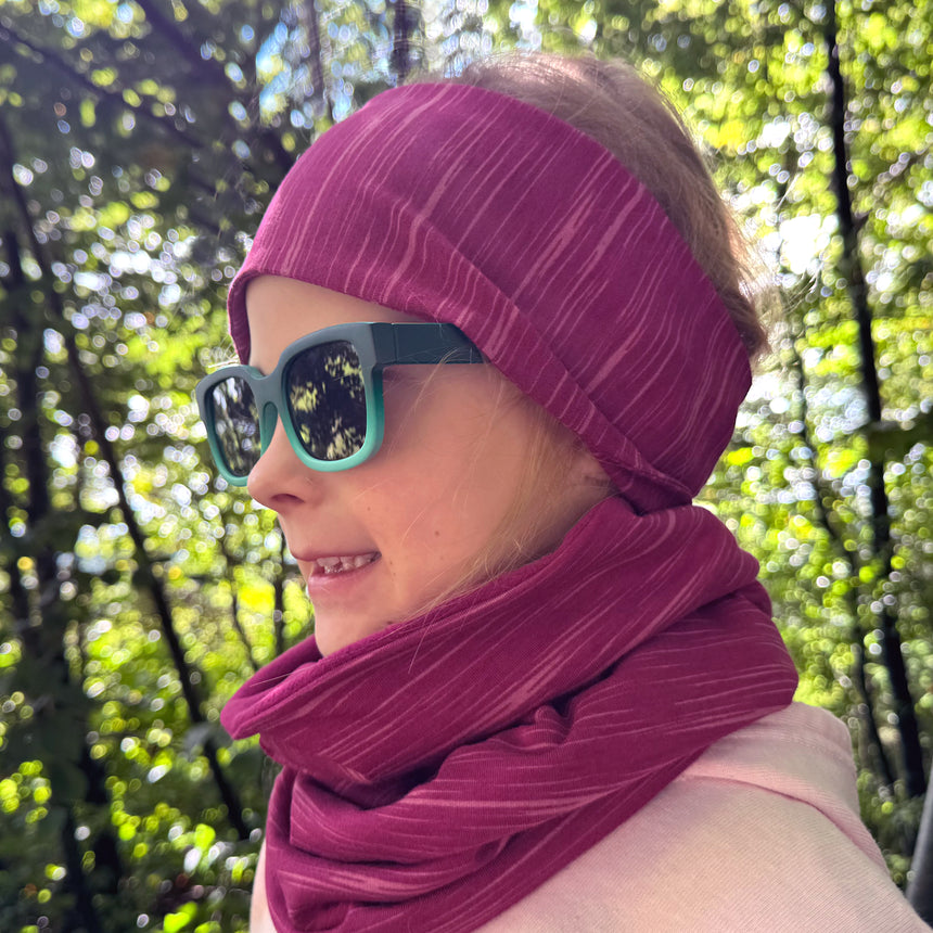 Mädchen trägt Wollhuhn LONG Loop, Jersey- oder Fleecefutter, schützt vor Kälte und Sonne. Handgemacht und komfortabel, ideal für Kinder und Erwachsene.