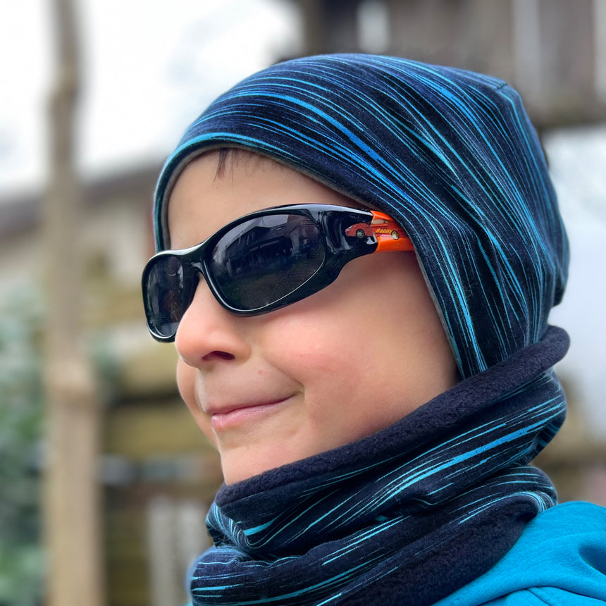 Junge trägt Wollhuhn Öko Shorties Wendemütze, stylisch und bequem, ideal für aktive Kinder.