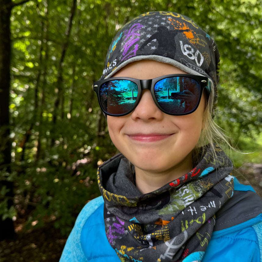 Frau trägt Wollhuhn LONG Loop, anthrazit, mit Jersey- oder Fleecefutter, ideal für Komfort und Schutz, handgefertigt in Deutschland, reflektiert hohe Qualität und Stil.