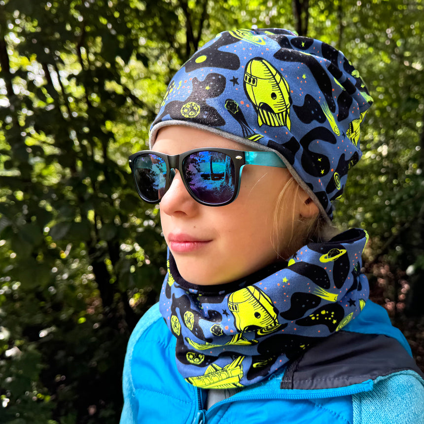 Mädchen trägt Wollhuhn LONG Loop, Jersey- oder Fleecefutter, Space Neon Gelb, kombiniert mit Sonnenbrille und Schal, ideal für Komfort und Schutz.
