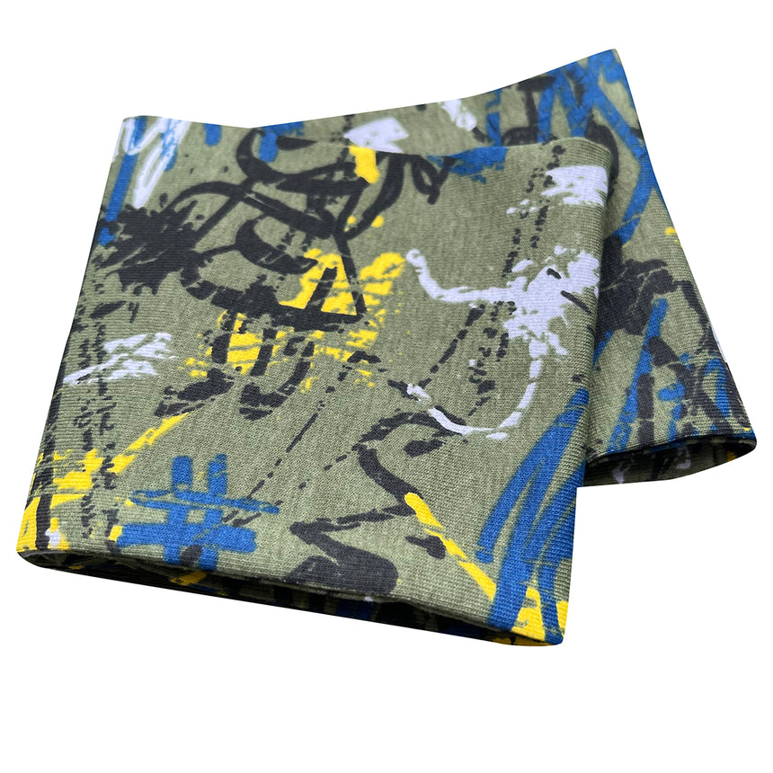 Wollhuhn Elastisches Öko Stirnband, zweilagig und breit, zeigt bunte Graffiti-Muster auf gefaltetem Stoff; handgemacht, weich und vielseitig tragbar.