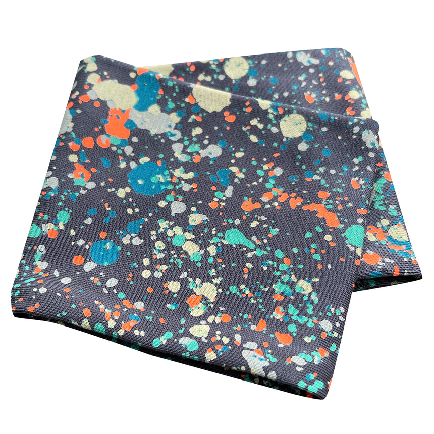 Wollhuhn Elastisches Öko Stirnband aus Jersey, zweilagig und breit, mit Splatter-Muster. Handgefertigt, weich und vielseitig, ideal für Alltag und Sport.