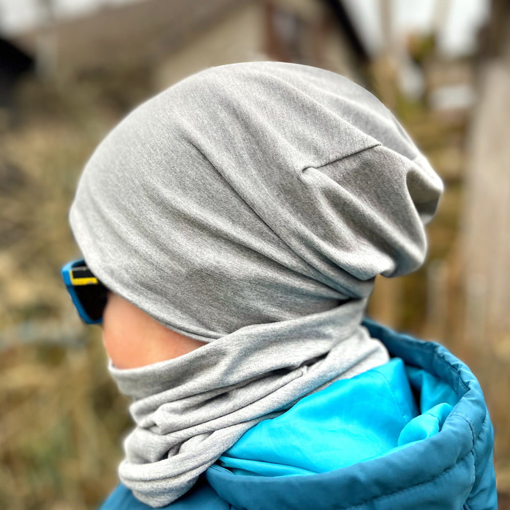 Wollhuhn Öko Long Beanie / Wendemütze, getragen von einer Person, kombiniert Komfort und Stil, ideal für Kinder, mit zweilagigem Jersey, für ganzjähriges Tragen.