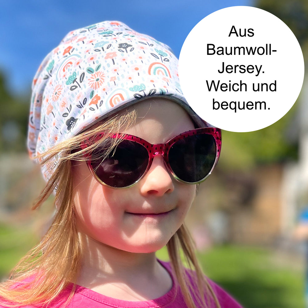 Mädchen trägt Wollhuhn Öko Shorties Wendemütze, zweilagig. Stilvolle Beanie aus weichem Baumwolljersey, ideal für Kinder, sorgt für Komfort und Wärme.