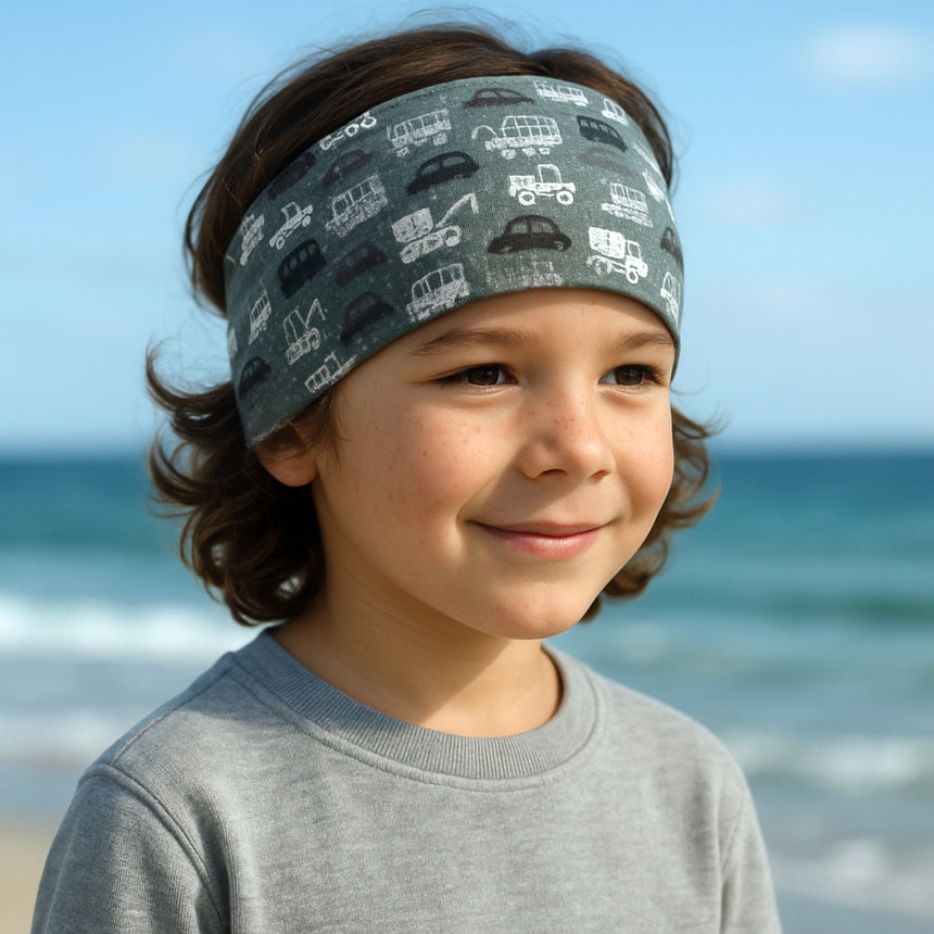 Junge am Strand trägt Wollhuhn Elastisches Öko Stirnband, handgemacht, weich und vielseitig. Perfekt für Freizeit und sportliche Aktivitäten. Ideal für Kinder und Erwachsene.