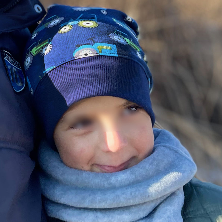 Person trägt Wollhuhn Dünne Öko Beanie-Mütze, ideal für Sommer/Übergang. Bequem, dehnbar, handgemacht in Deutschland, perfekt für Kinder.