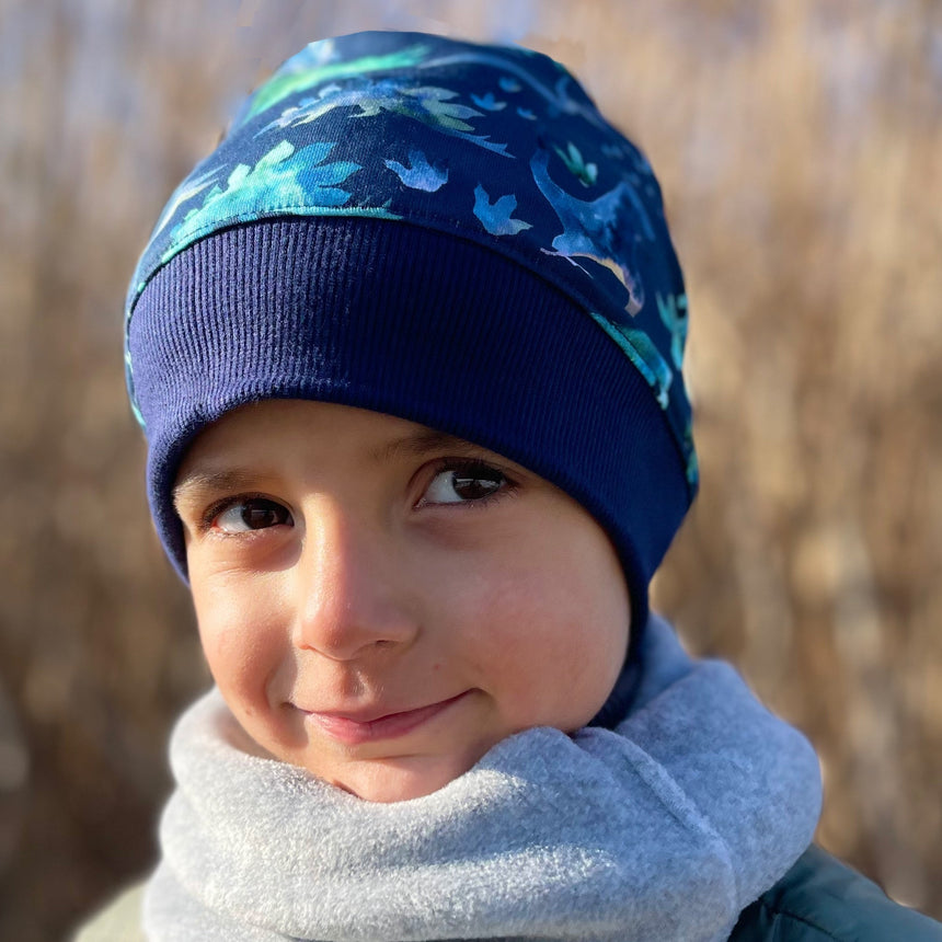 Kind trägt Wollhuhn Dünne Öko Beanie-Mütze Sommer/Übergang, einlagig, jeansblau meliert, aus weichem, elastischem Öko-Jersey, ideal für kühle Tage.