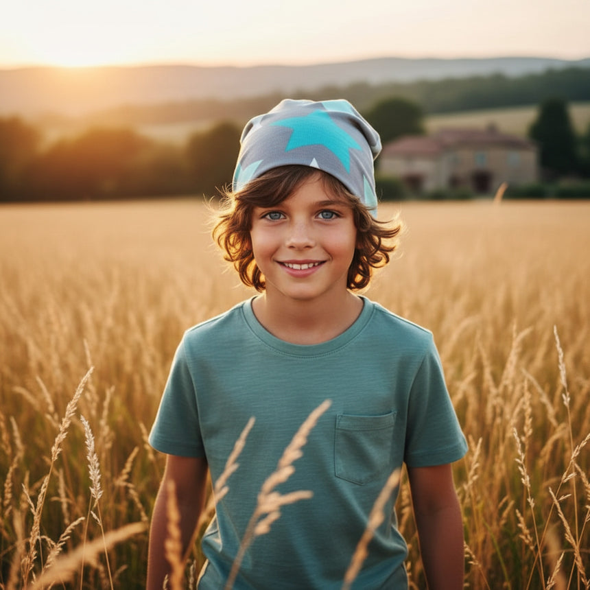 Ein Junge trägt die Wollhuhn Öko Long Beanie / Wendemütze im Feld, ideal für alle Jahreszeiten, bequem und stilvoll, handgefertigt in Deutschland.