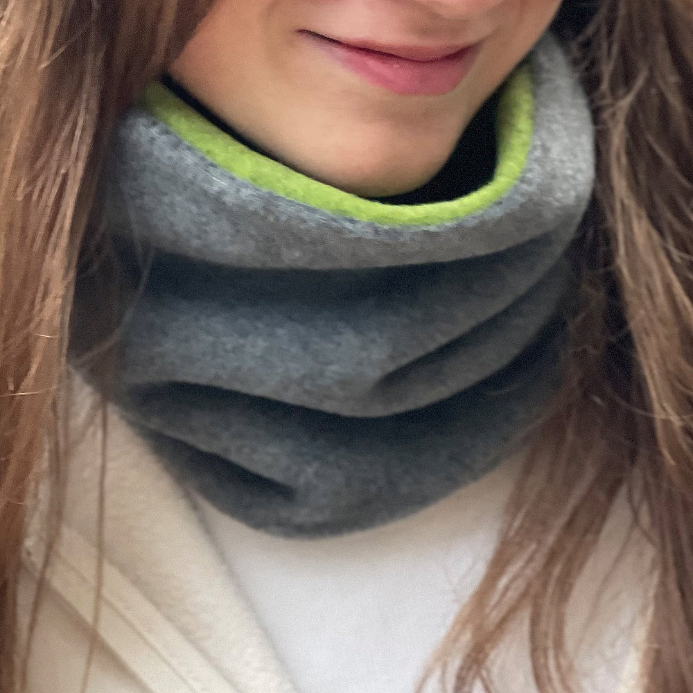 Wollhuhn WINTER Halstuch/Schlupfschal „Unser Wärmster“ aus zwei Lagen Fleece. Eine Frau trägt den gemütlichen und winddichten Schlauchschal. Ideal für kalte Tage.