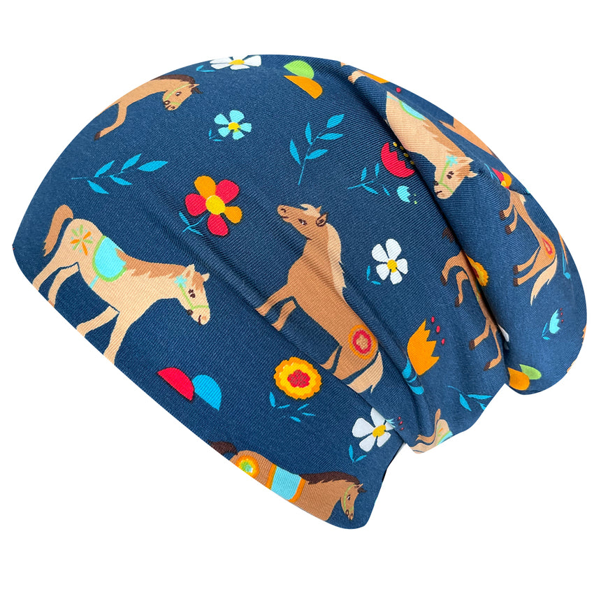 Wollhuhn Öko Long Beanie / Wendemütze, Pony Blau: Blaues Beanie mit Pferde- und Blumenmuster, aus weichem Baumwolljersey, zweilagig, wendbar und ideal für Kinder.