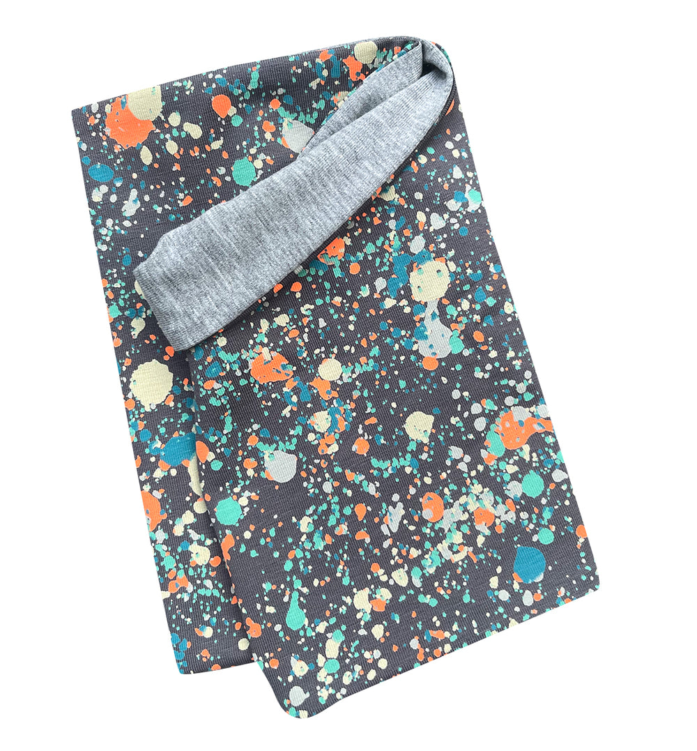 Wollhuhn Leichtes Öko Jersey Halstuch mit Splatter-Muster auf Stoff, handgefertigt, ideal für Kinder, locker und einfach über den Kopf zu ziehen.