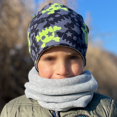 Kind trägt Wollhuhn Öko Long Beanie / Wendemütze, Ganzjährig, Zweilagig, Coole Skulls Anthrazit/Lime. Bequem, doppellagig, ideal für Kinder, hält Ohren warm.