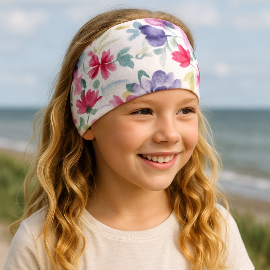 Mädchen mit blondem Haar trägt ein Wollhuhn Elastisches Öko Stirnband, handgemacht, Jersey zweilagig, ideal für Kinder und Erwachsene, Blumenmuster.