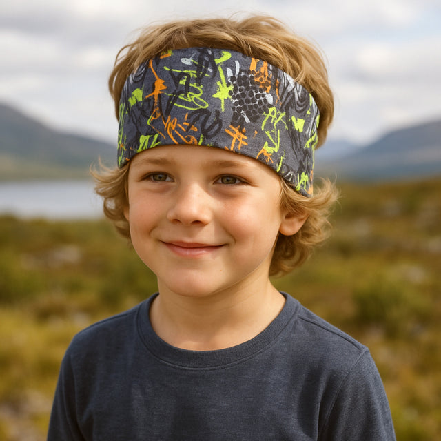 Junge trägt Wollhuhn Elastisches Öko Stirnband, Jersey, zweilagig, breit, ideal für Outdoor-Aktivitäten, handgemacht in Deutschland. Perfekt für Kinder und Erwachsene.