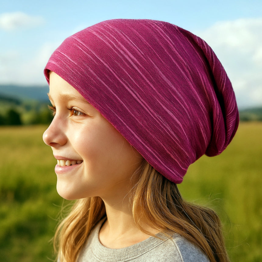 Mädchen trägt Wollhuhn Öko Long Beanie, zweilagig, handgefertigt aus weichem Baumwolljersey, ideal für ganzjähriges Tragen.