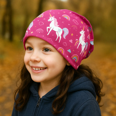 Ein Mädchen trägt eine Wollhuhn Öko Long Beanie/Wendemütze mit Einhornmotiv im Herbst. Perfekt für lässigen Komfort und Wärme. Handgemacht in Deutschland.