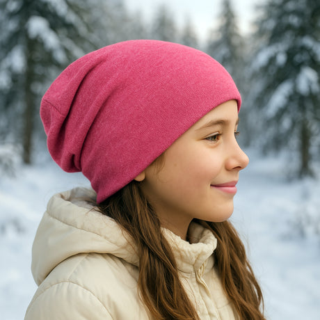 Mädchen im Wald trägt Wollhuhn Öko Long Beanie, zweilagig und wendbar, ideal für Winter, mit lockerem Sitz, gefertigt aus weichem, dehnbarem Öko-Jersey.
