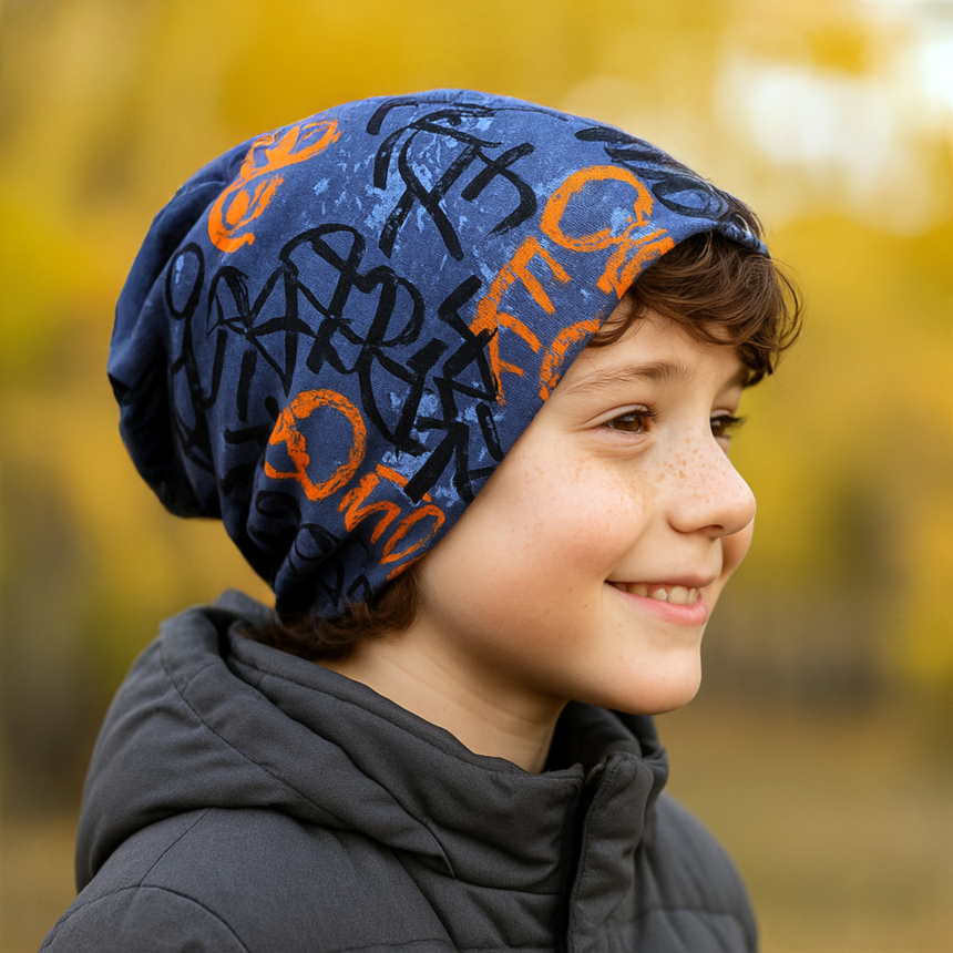 Junge mit Wollhuhn Öko Long Beanie, Skater Grau/Orange, lässig getragen, zeigt zweilagiges, wendbares Design für ganzjährigen Komfort und Wärme.