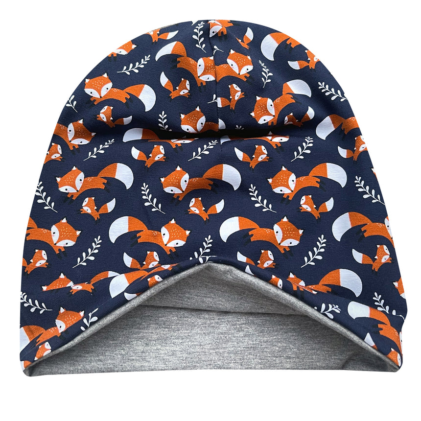 Wollhuhn Öko Long Beanie: Dunkelblau mit orange-weißen Fuchsmotiven, wendbar, zeigt graues Innenfutter. Handgemacht aus weichem, dehnbarem Öko-Jersey für stilvollen, bequemen Sitz.
