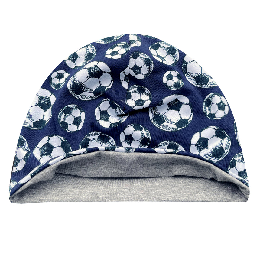 Wollhuhn Öko Shorties: Blaue Beanie mit Fußballmuster, weich und dehnbar, wendbar mit grauer Innenseite, ideal für aktive Kinder. Handgefertigt in Deutschland.