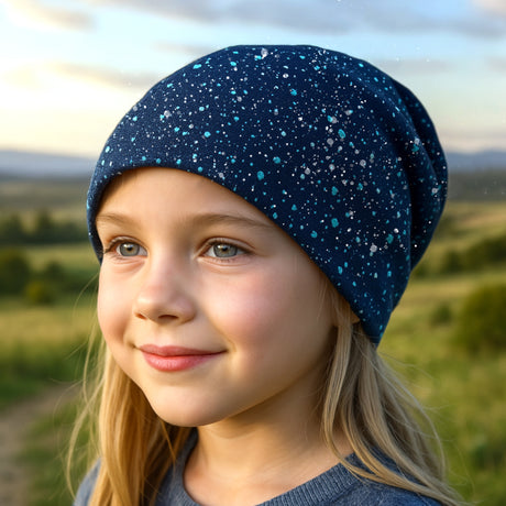 Mädchen mit blauer Wollhuhn Öko Shorties Wendemütze, zweilagig und handgemacht, perfekt für aktive Kinder.