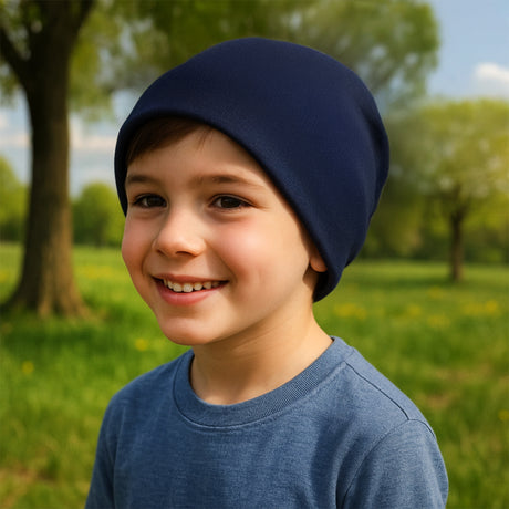 Junge mit Wollhuhn Öko Shorties Beanie, zweilagig, dunkelblau, lächelnd. Ideal für aktive Kinder, handgefertigt in Deutschland. Perfekt für Freizeit und Sport.