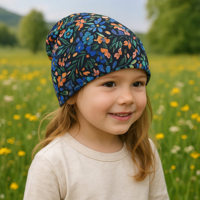 Mädchen mit Blumenhut trägt Wollhuhn Öko Shorties, zweilagig, handgenäht, ideal für aktive Kinder, mitwachsend und bequem unter Helmen.