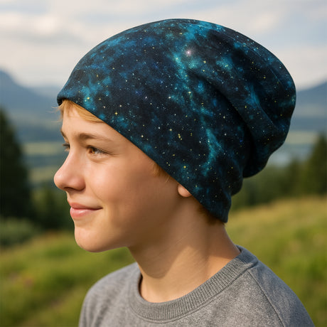 Junge trägt Wollhuhn Öko Shorties, Wendemütze, zweilagig, Space Blau/Grün, lächelt im Freien, weiche Beanie für aktive Kinder, handgemacht in Deutschland.