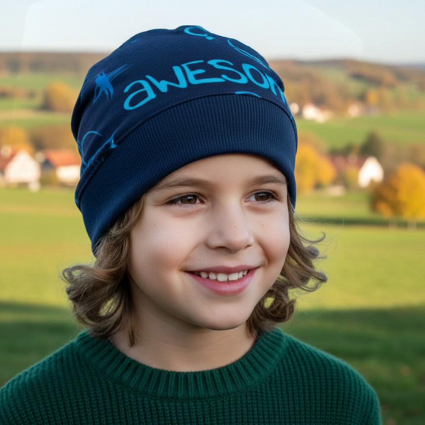 Kind trägt Wollhuhn Dünne Öko Beanie-Mütze Sommer/Übergang Einlagig Cool Music Blau, lächelnd in ländlicher Herbstlandschaft. Handgemacht, dehnbar, ideal für aktive Kinder.