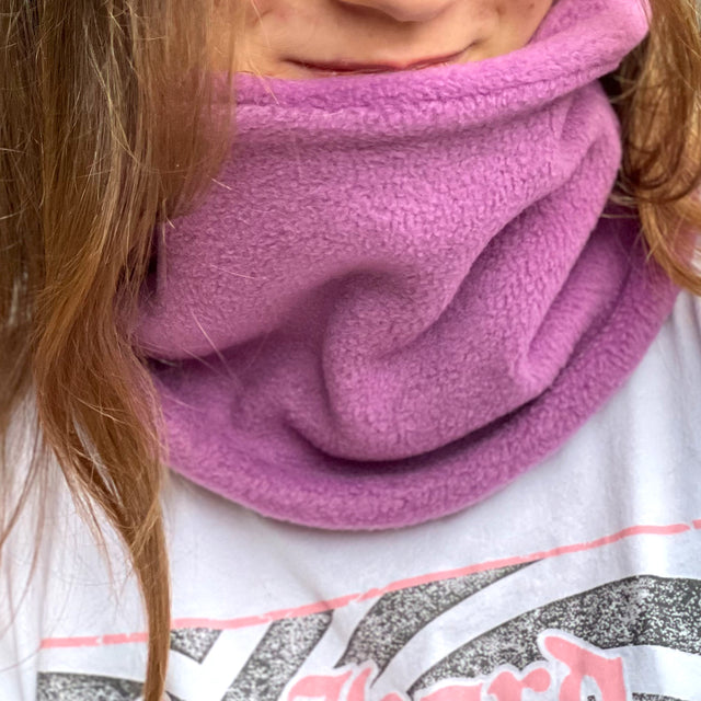 Mädchen trägt Wollhuhn WINTER Halstuch/Schlupfschal „Unser Wärmster“, doppellagiger Fleece in Flieder, handgefertigt, ideal für Kinder und Erwachsene, schützt vor Kälte.