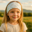 Mädchen mit blondem Haar trägt das Wollhuhn Elastisches Öko Stirnband, handgefertigt, vielseitig, ideal für Kinder und Erwachsene, weich und hautfreundlich.